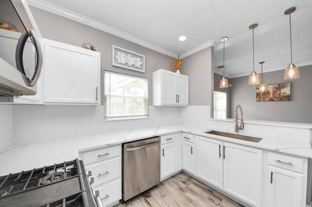Kitchen features updated cabinets, quartz countertops and recent appliances.