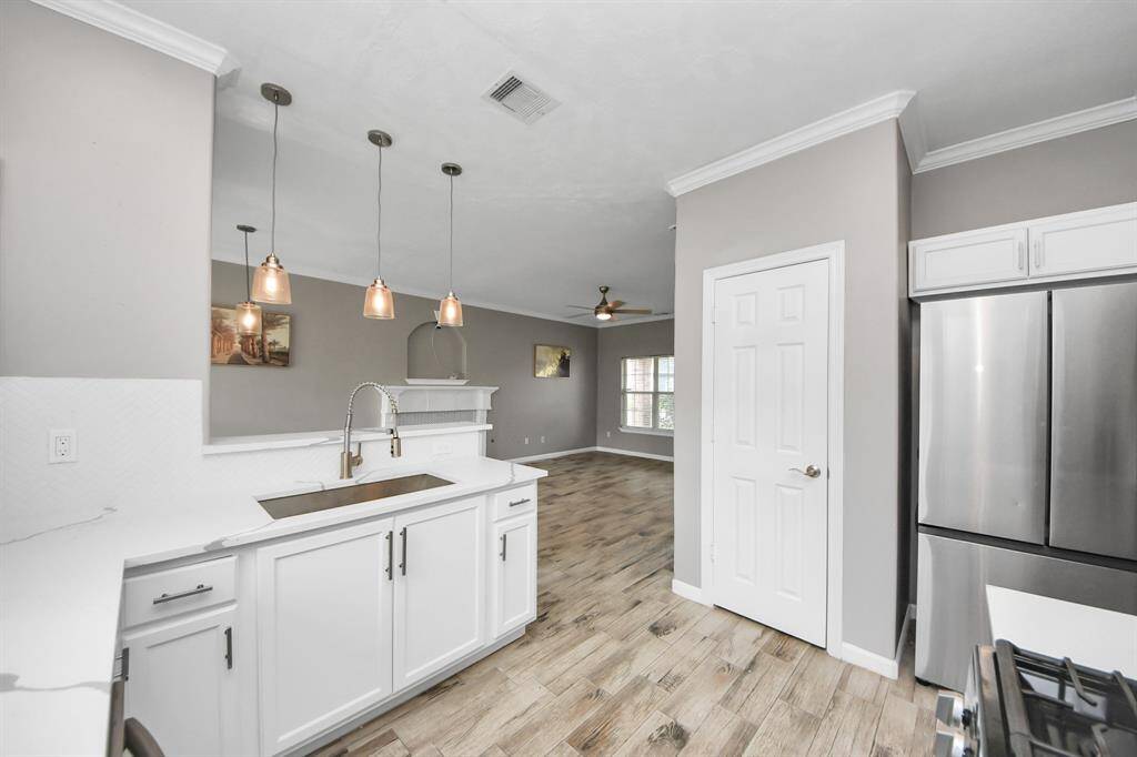 Kitchen features updated cabinets, quartz countertops and recent appliances.