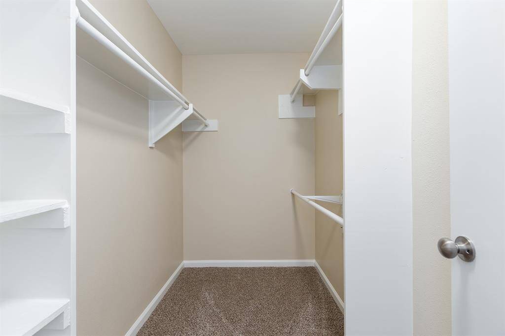 Spacious walk-in closet with custom built-ins.