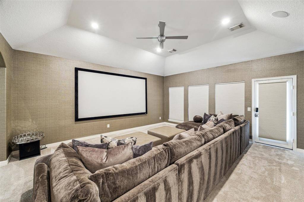 The upstairs media room has a projector and screen with access to the covered second floor outdoor living.