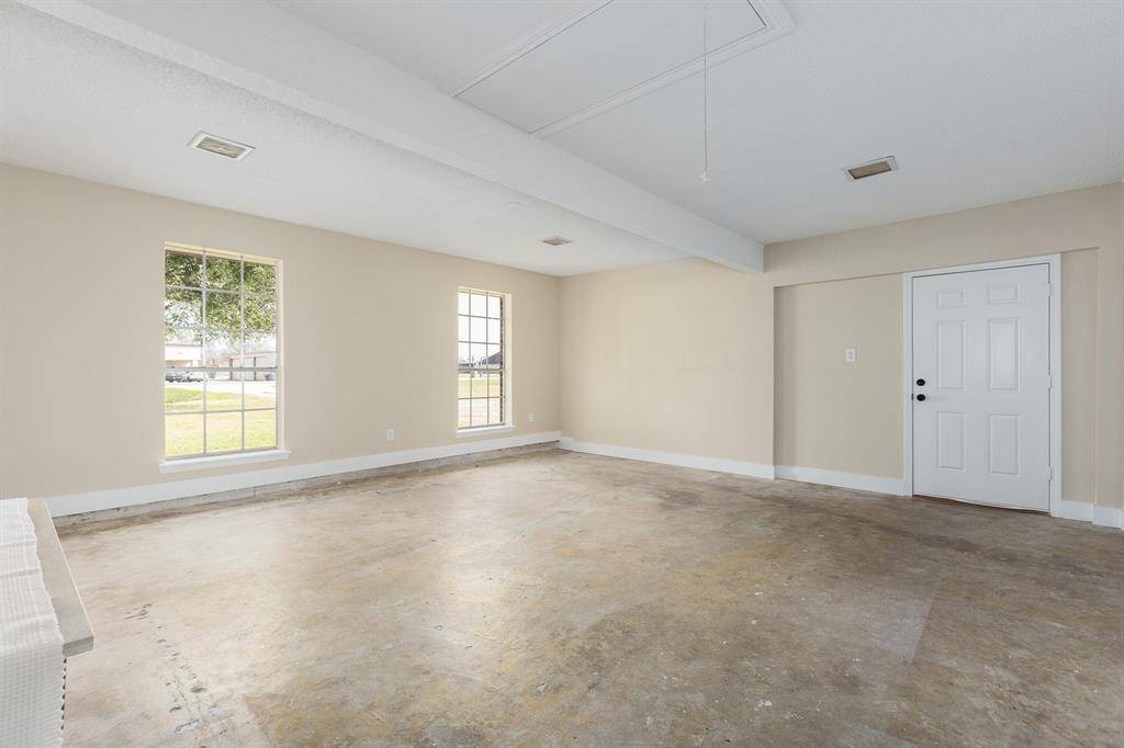 Enclosed garage features a convenient utility room and direct access to the carport.