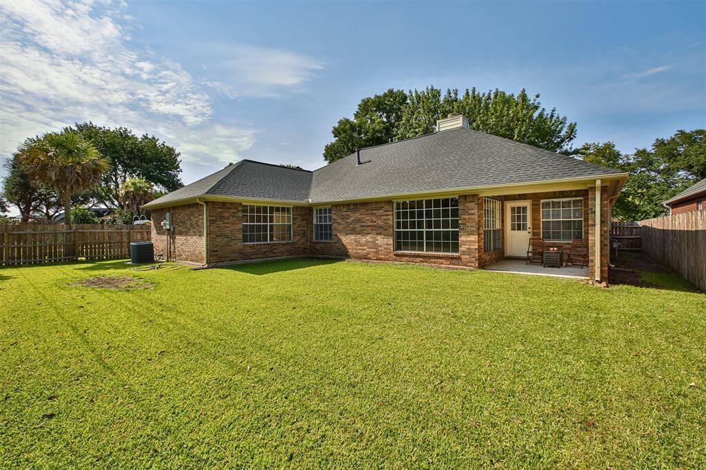 Another view of the backyard. Nice covered patio has enough room to enjoy cool mornings and nights. This home is finished with brick all around.