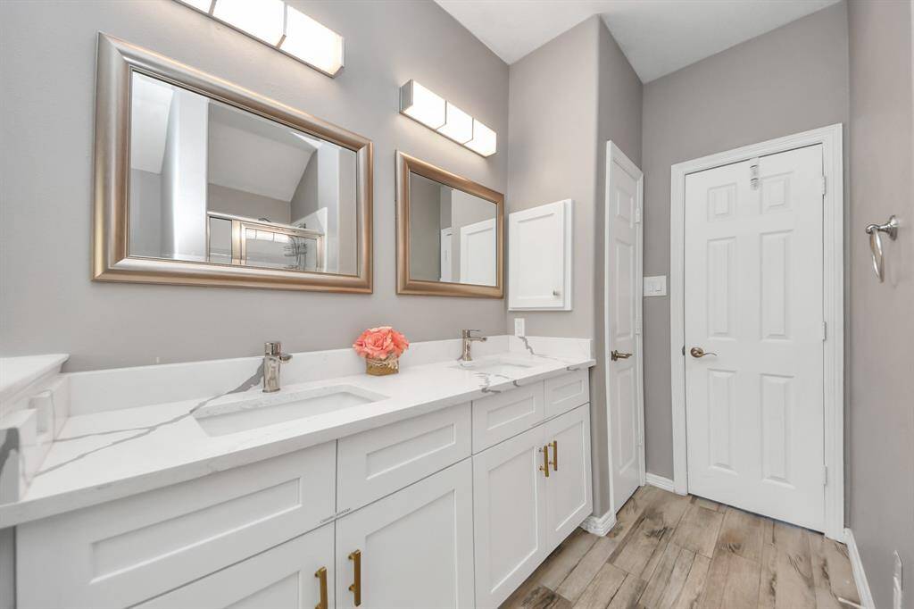 The primary bathroom features double sinks, stylish lighting and framed mirrors for the convenience of the owner(s) of the home.