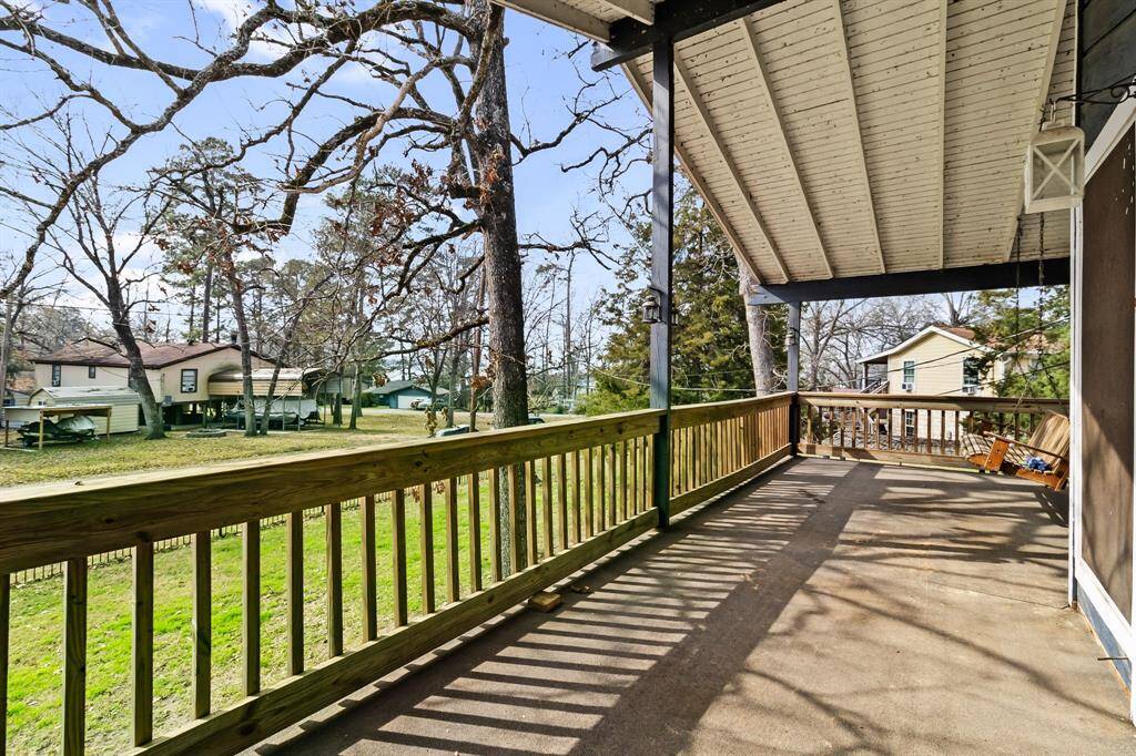 Relax and unwind on the second-floor balcony, complete with a charming bench swing and views of the surrounding property—perfect for enjoying a quiet morning or evening breeze.