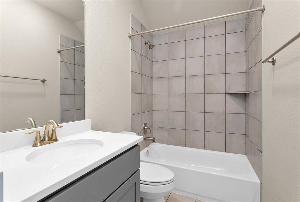 The full secondary bedroom with tile enclosure around the tub/shower combo. This is located conveniently next to the two other secondary bedrooms.