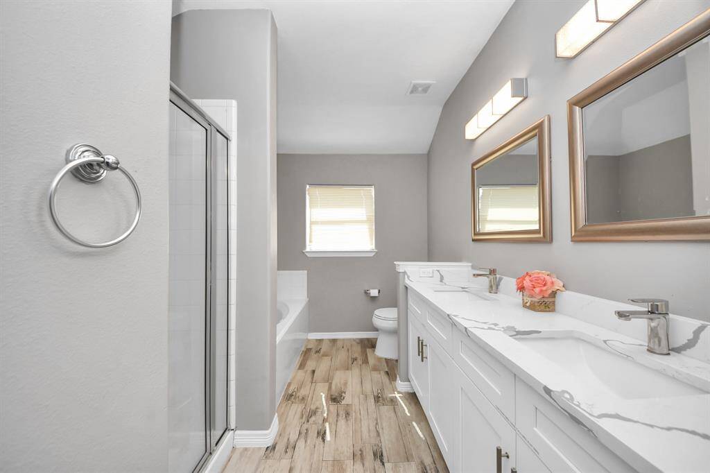 The primary bathroom features double sinks, stylish lighting and framed mirrors for the convenience of the owner(s) of the home.