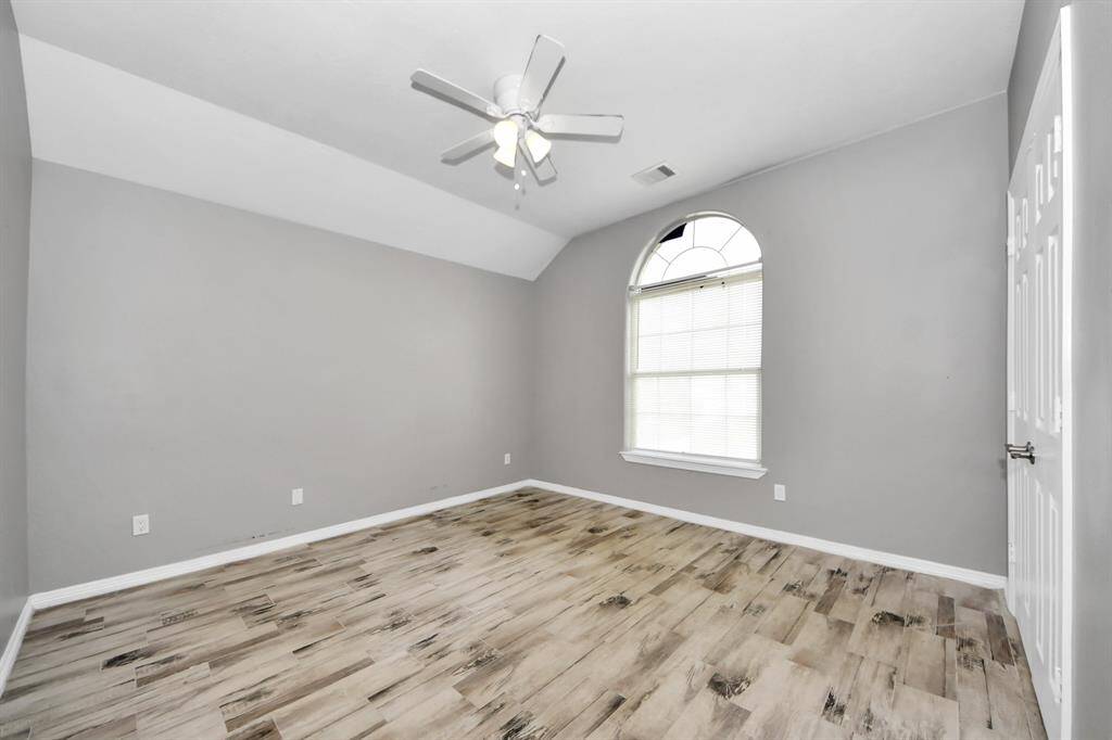 This bright room features light flooring, neutral gray walls, a ceiling fan and offers a modern and airy feel.