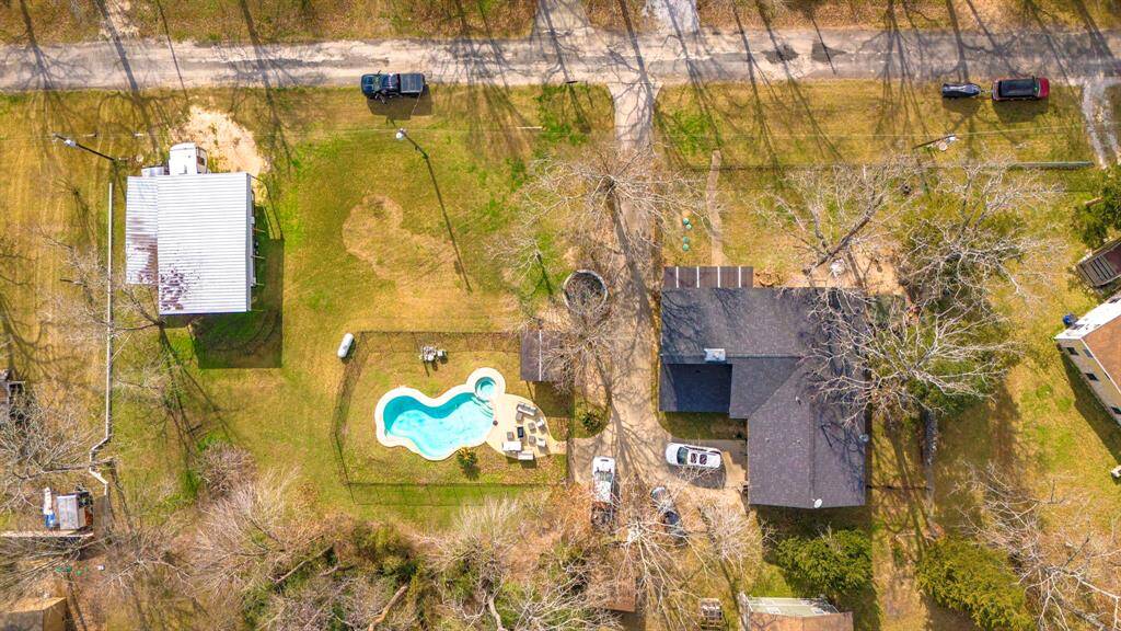 Birds-eye perspective of the private backyard oasis featuring a pool, hot tub, and outdoor entertaining space.