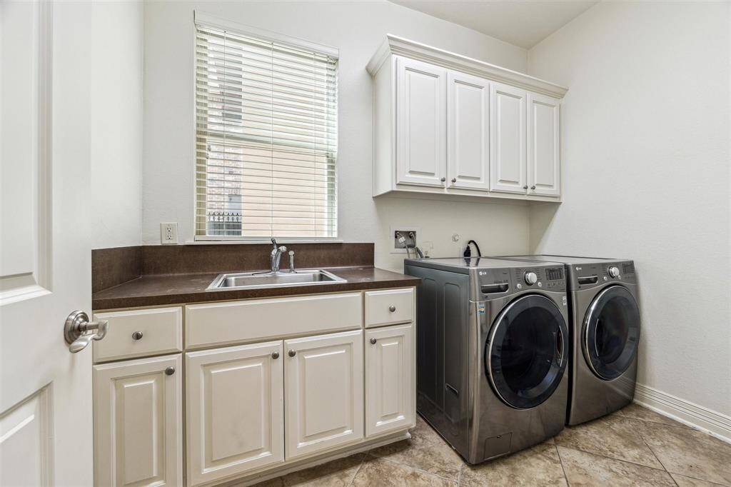 The downstairs utility rom has a soaking sink and additional cabinet storage