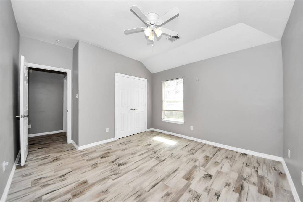 This bright room features light flooring, neutral gray walls, a ceiling fan and offers a modern and airy feel.