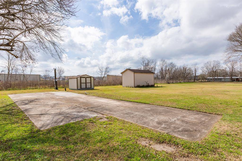 Expansive backyard featuring a large grassy area with two large storage sheds.  Concrete pad for RV or Trailer.  This area has it's own access to septic and electrical service.