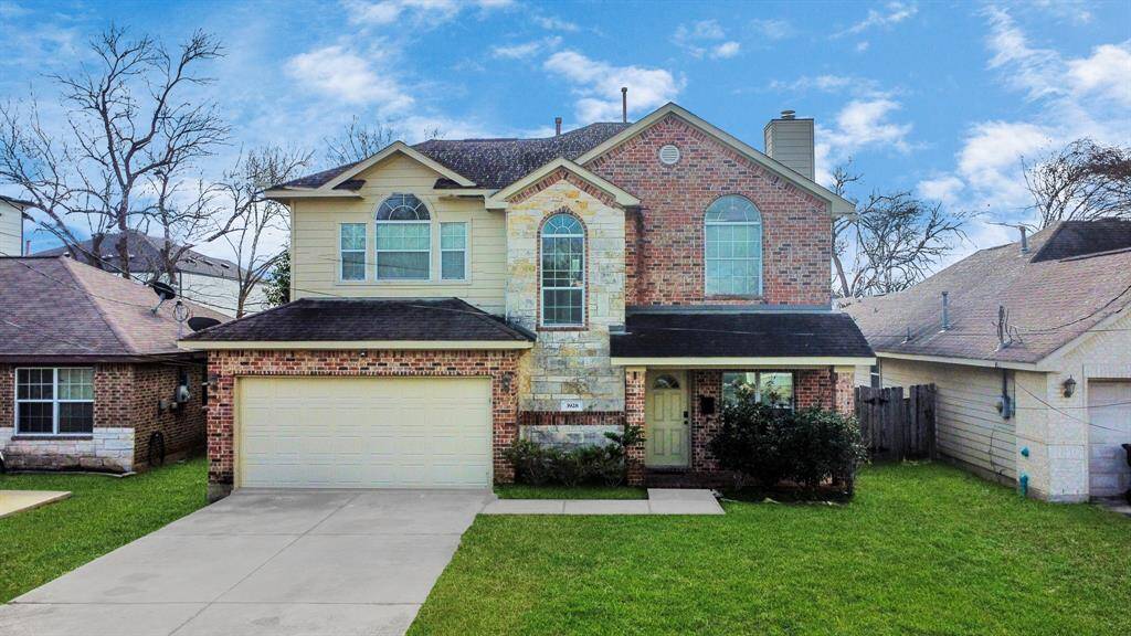 3928 McKinley features a symmetrical facade with large arched windows and a well-maintained front yard.