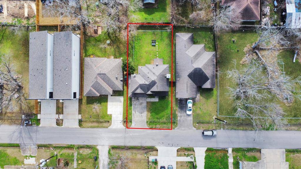 Situated in a residential neighborhood. The property features a spacious backyard and is flanked by neighboring houses on either side.