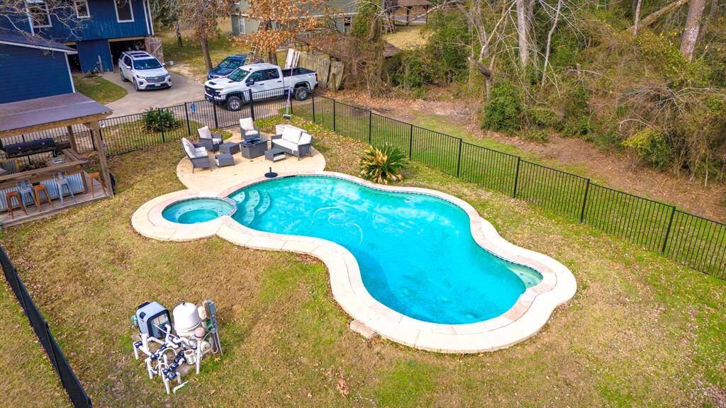 Birds-eye perspective of the private backyard oasis featuring a pool, hot tub, and outdoor entertaining space.