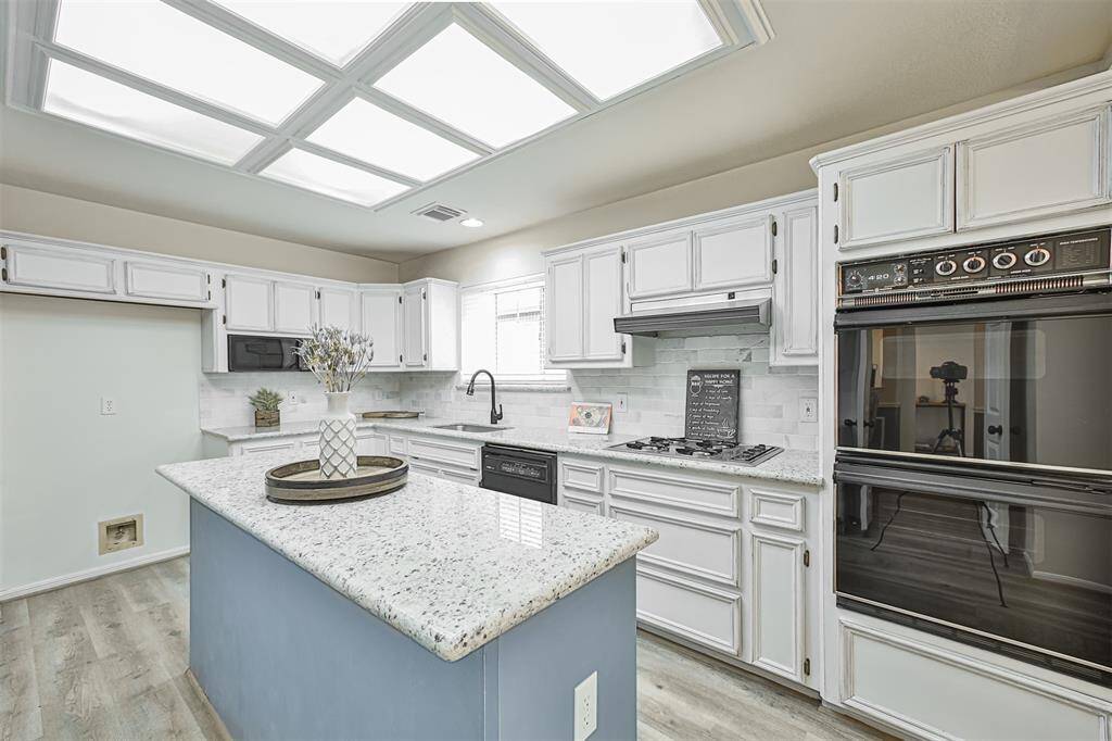 White distressed cabinets are complimented with an island in vintage French blue color.