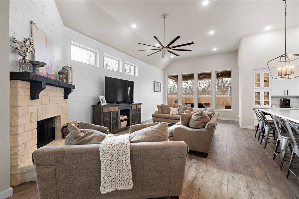 A beautiful stone fireplace anchors the inviting family room. Upgraded flooring flows seamlessly throughout the living spaces.