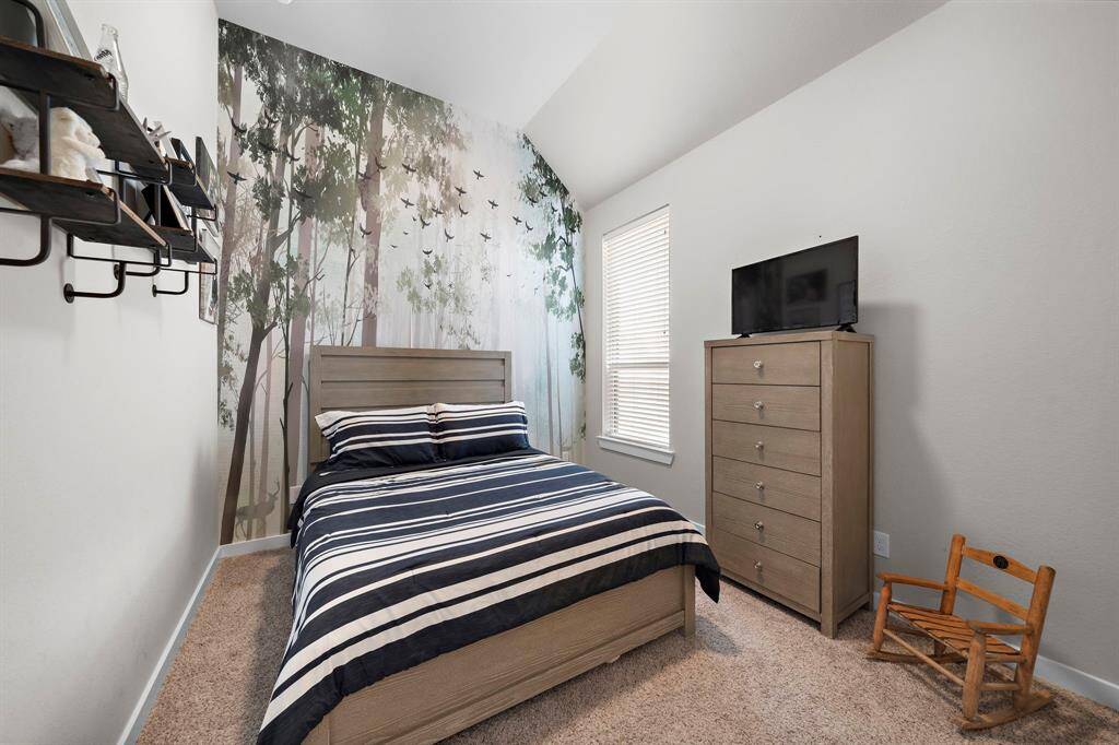 A secondary bedroom featuring a walk-in closet.