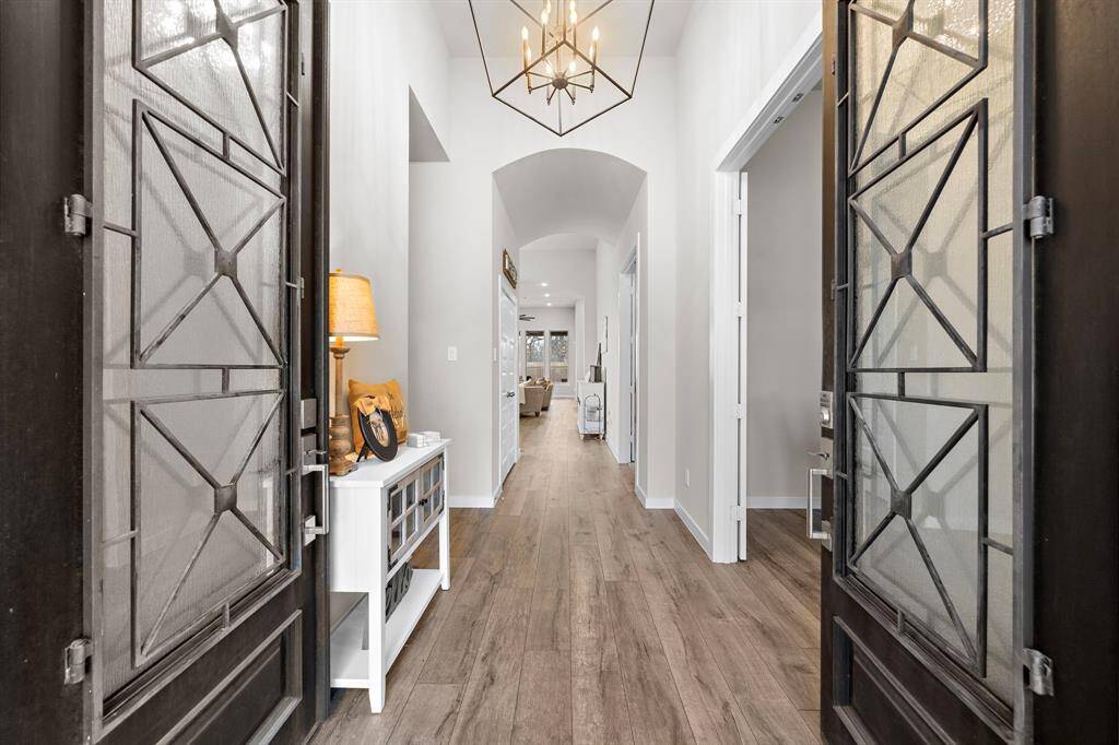 Upgrades throughout the home include designer lighting, custom shutters, and charming shiplap walls. The gourmet kitchen is a chef’s dream, offering a large island, sleek countertops, stainless steel appliances, glass-front display cabinets, and built-in wine storage
