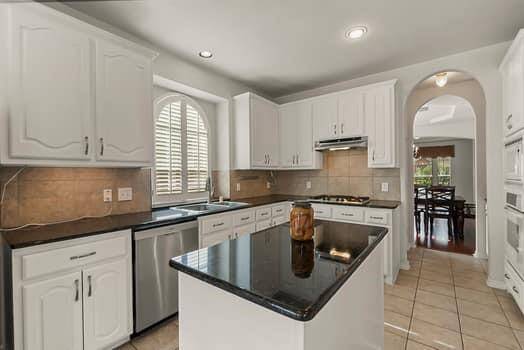 Great kitchen with granite counter tops, recent resurfaced cabinets with pull outs , gas cook top and tile backsplash