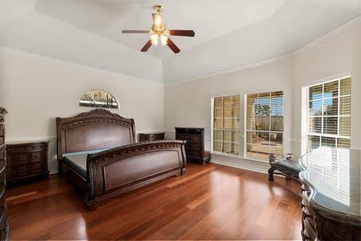Large primary suite with wood floors, ceiling fans and great windows overlooking the pool