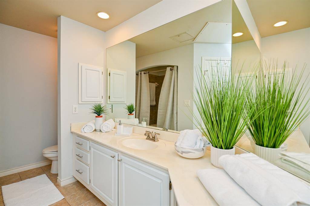 The spacious bathroom is bathed in light. Stylish decor makes the space feel clean.