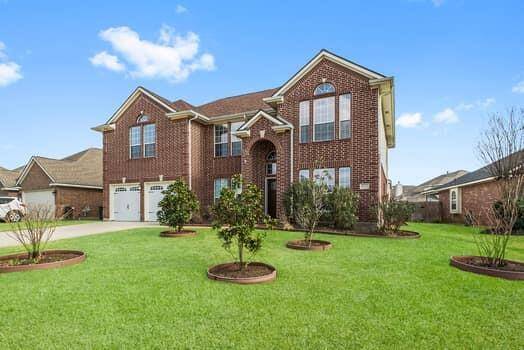 This impressive two-story brick home features a spacious front yard with well-maintained landscaping, updated double garage doors and large windows for abundant natural light.