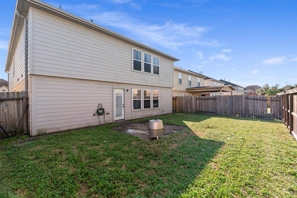 Large backyard with concrete patio.