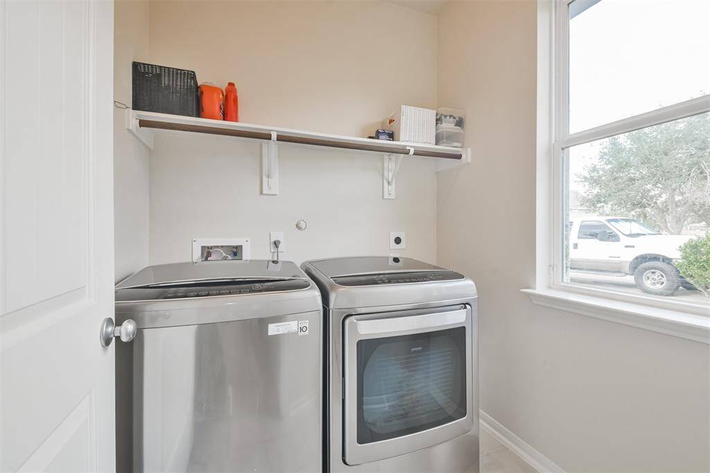 Indoor utility room featuring storage shelves and a clothes rack.