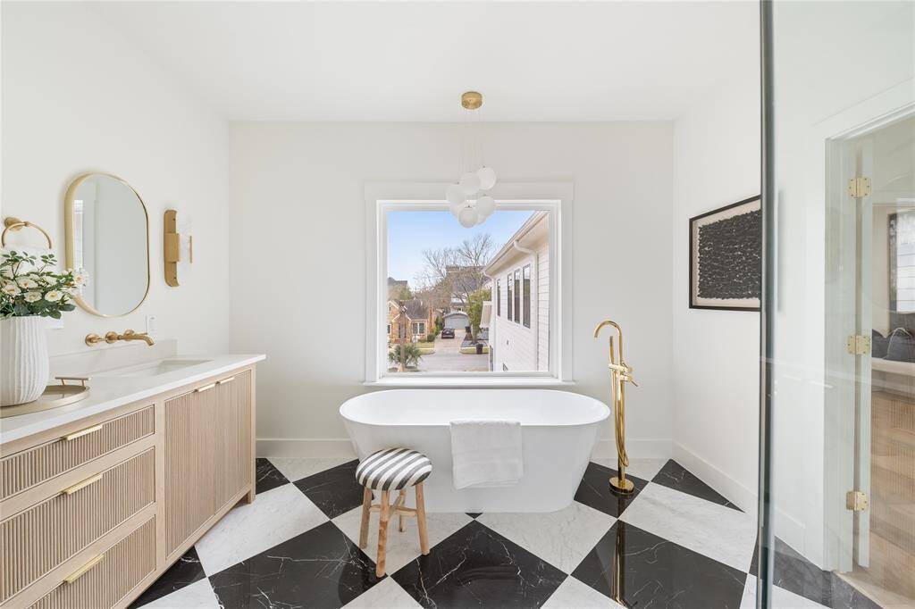 A true spa-like retreat—this primary bath features a spacious walk-in shower, a luxurious soaking tub, and a designer dual-sink vanity, all bathed in natural light from a beautiful window.