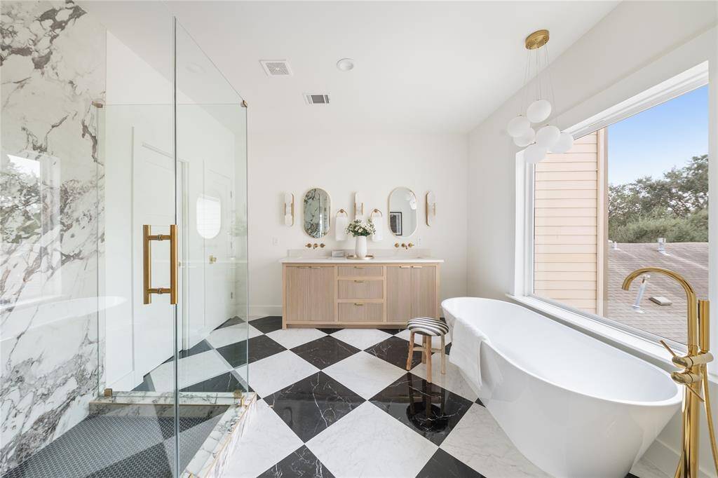 Timeless elegance meets modern convenience in this stunning primary bath, complete with a walk-in shower, freestanding soaking tub, and a custom vanity with dual sinks.