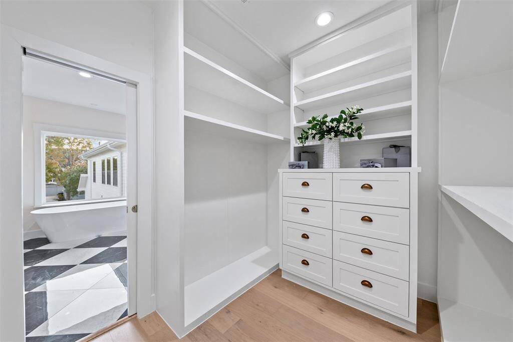 Designed for comfort and convenience, the primary bath leads into a spacious walk-in closet with built-in storage and extra washer/dryer hookups for effortless living.