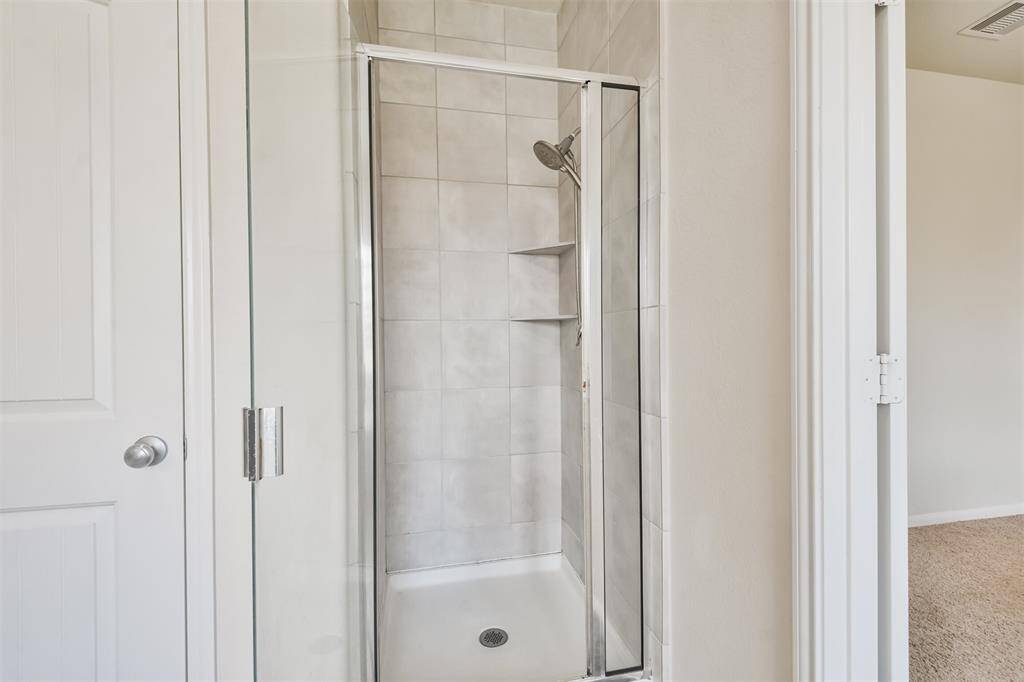 Enclosed walk-in shower featuring elegant ceramic tile design.