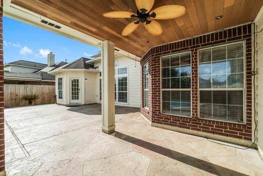 This aerial photo showcases a spacious home , featuring a private backyard with a swimming pool. The property includes a large driveway and is situated in a well-maintained neighborhood with green lawns and nearby homes.