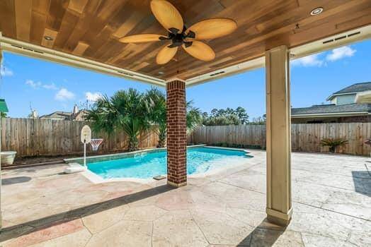 This inviting home features  a sparkling pool and a covered patio. The exterior showcases large windows, allowing natural light to fill the interior. Perfect for relaxation and entertaining.