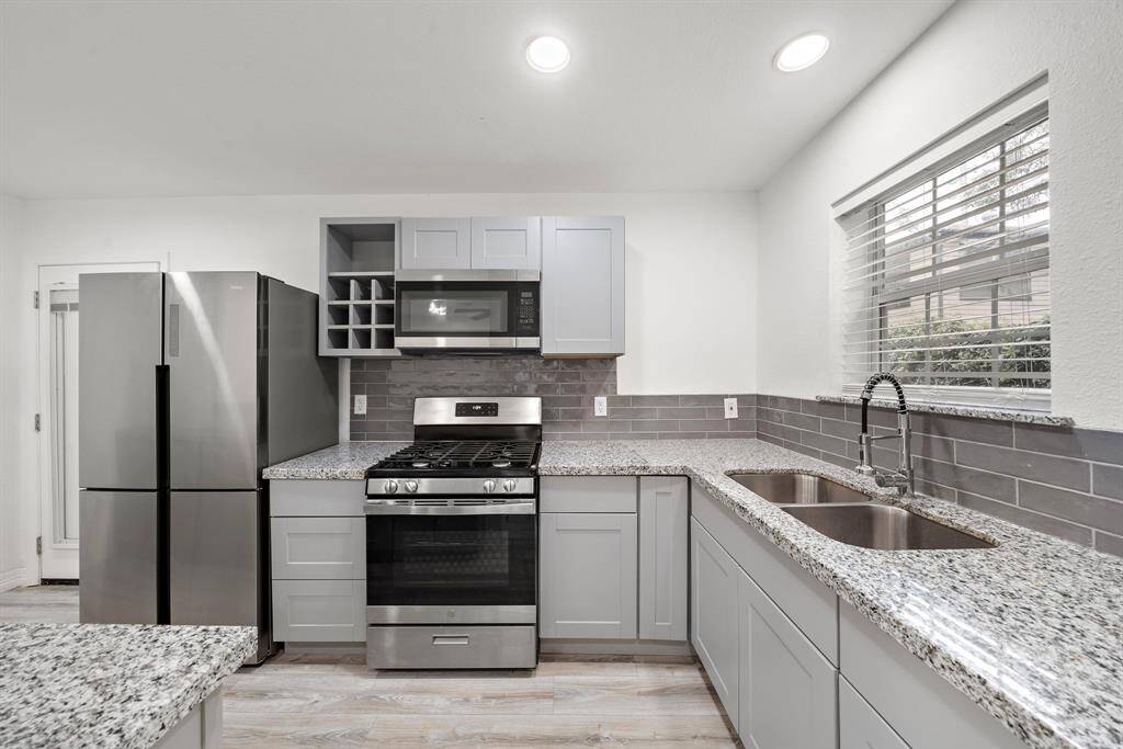 The Kitchen in the main home with a well-lit gray aesthetic features.