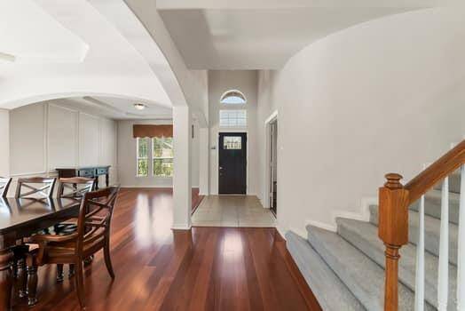Overview of the entry way from the family room.  Open floor plan with high ceilings and wood floors