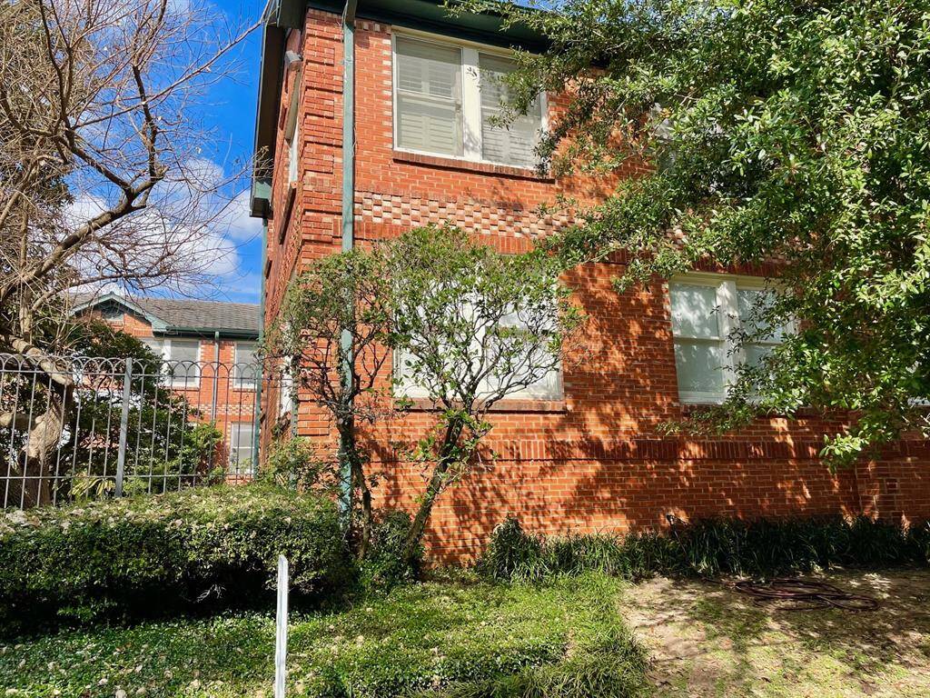 UNIT 14 is the 1st Floor corner unit shaded by green trees and shrubbery.
