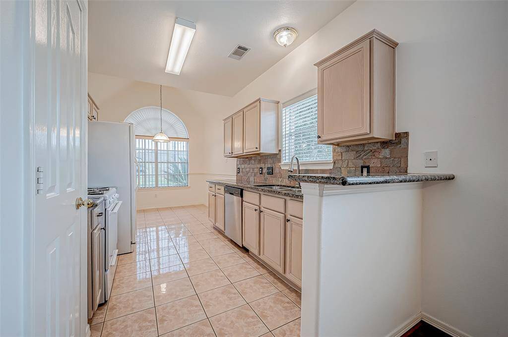 Tiled flooring subtly defines the kitchen as its own space while maintaining an open connection to the living area.