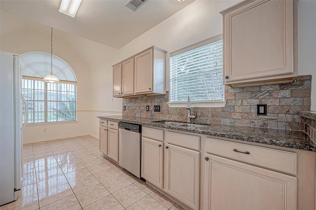 Ample cabinetry provides storage, and the textured backsplash introduces a stylish accent to the soft, neutral palette. The built-in microwave and gas range offer convenience, while spacious countertops make meal prep a breeze.