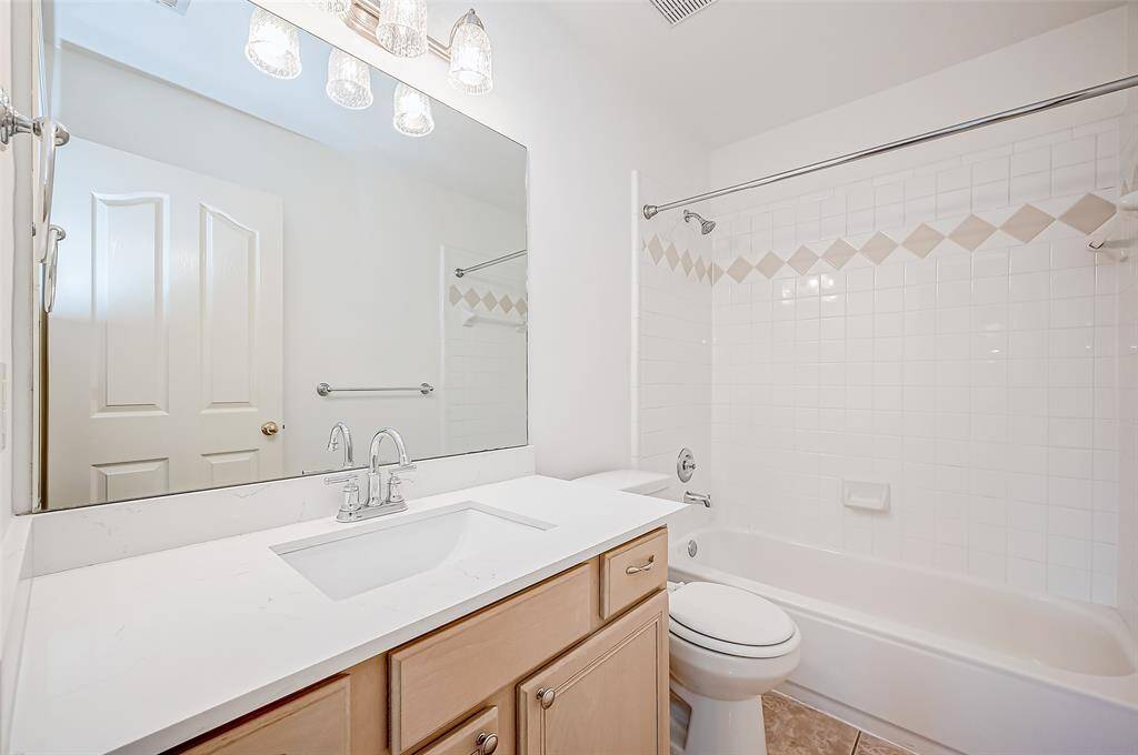 Thoughtfully designed, this bathroom features a wide countertop, ample storage, and a bright, polished look. The combination shower and tub allows for both quick rinses and relaxing soaks.