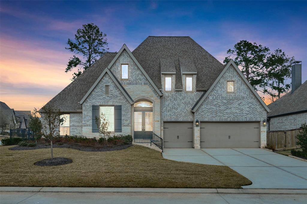 Beautiful sunsets await you in the evenings at 136 Hushed Nightfall in The Woodlands Hills. This grand home is situated on a spacious corner lot and features a 3-car garage, an incredible Open Concept Layout inside, perfect for entertaining friends and family. Digitally enhanced image.