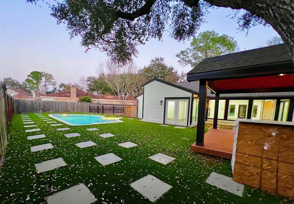 Turf back yard with resurfaced pool and hot tub