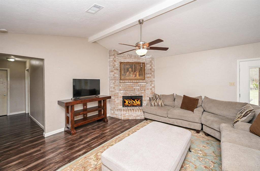 Approx. 21x13 Living Area with High Ceilings and a Brick-Faced Wood-Burning Fireplace.