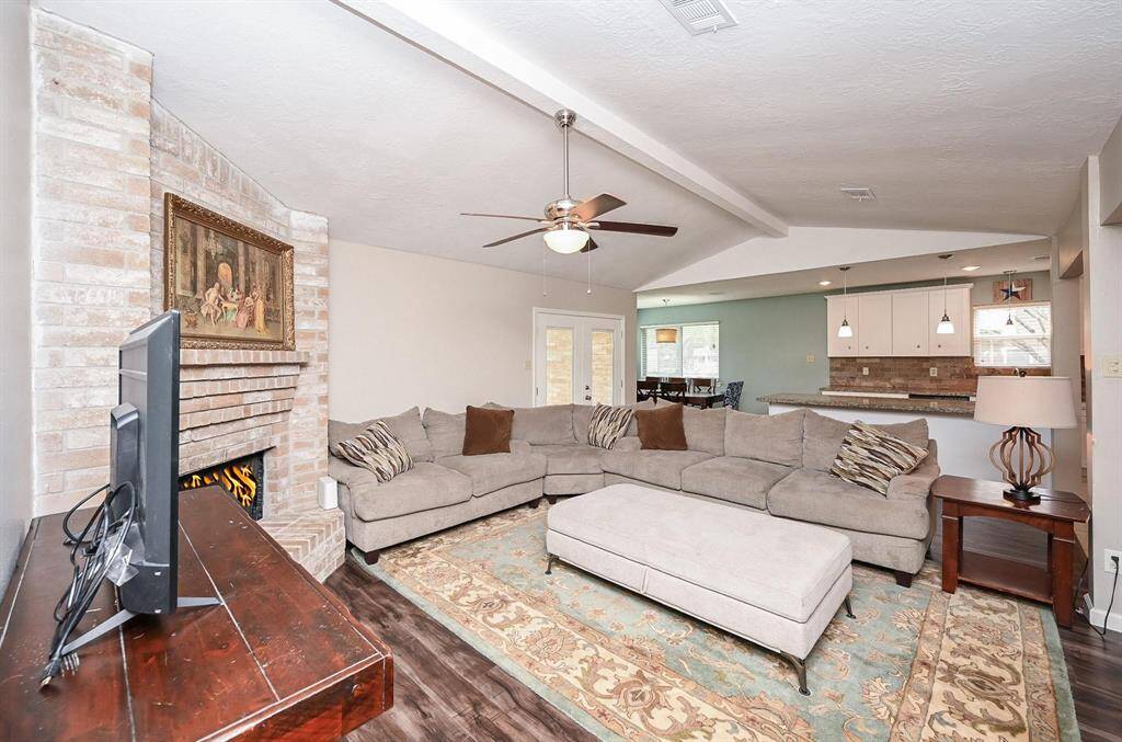 The approx. 21x13 Living Area with High Ceilings and a Brick-Faced Wood-Burning Fireplace is open to the Kitchen & Breakfast Room. The Double Glass Doors lead to the approx. 10x16 Covered Back Yard Patio and Large Back Yard.