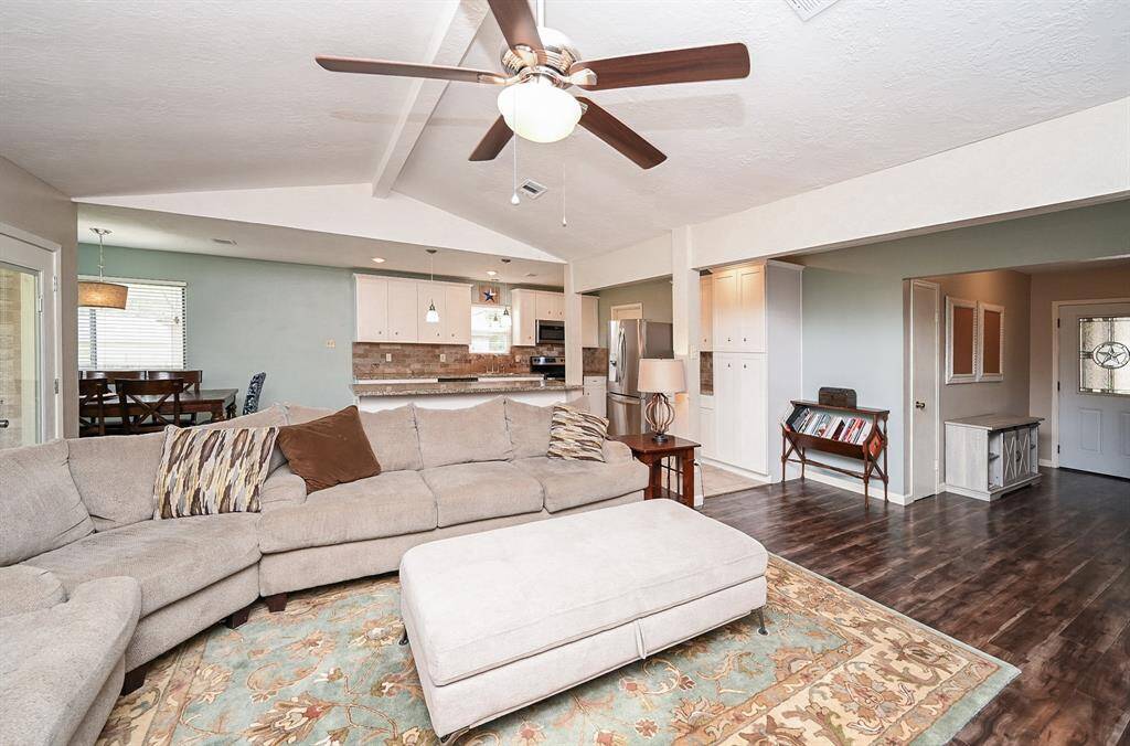 The approx. 21x13 Living Area with High Ceilings and a Brick-Faced Wood-Burning Fireplace is open to the Kitchen & Breakfast Room. The Double Glass Doors lead to the approx. 10x16 Covered Back Yard Patio and Large Back Yard.