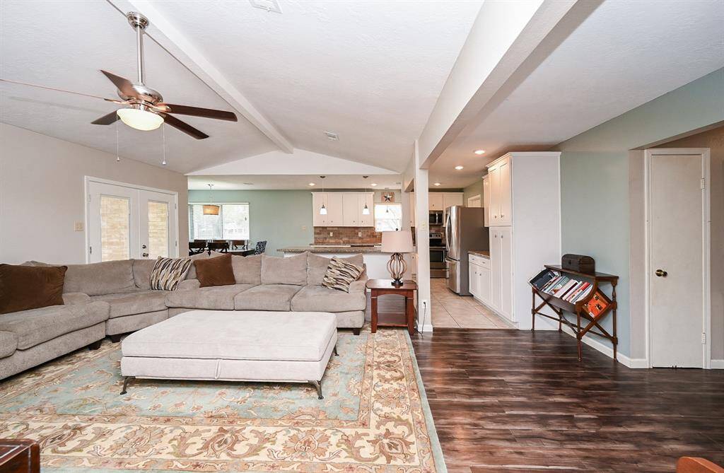 The approx. 21x13 Living Area with High Ceilings and a Brick-Faced Wood-Burning Fireplace is open to the Kitchen & Breakfast Room. The Double Glass Doors lead to the approx. 10x16 Covered Back Yard Patio and Large Back Yard.