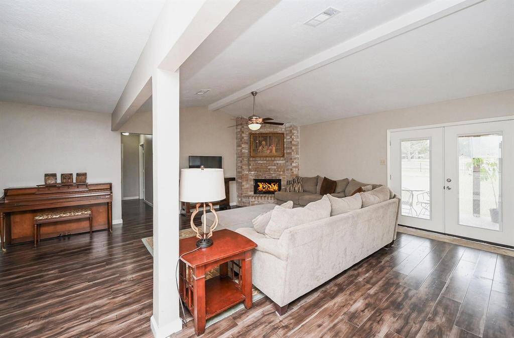 Approx. 21x13 Living Area with High Ceilings and a Brick-Faced Wood-Burning Fireplace.