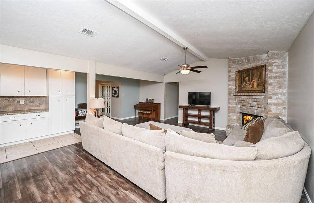 Approx. 21x13 Living Area with High Ceilings and a Brick-Faced Wood-Burning Fireplace.