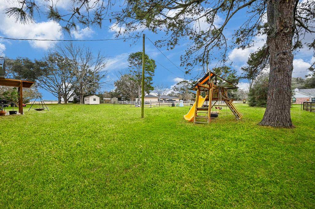 Back Yard View for this Classic 1-Story Home on approx. .75 Acres. Cul-de-Sac Street. Space for a Future Pool, Garden, Pets & Recreation. The Play Fort is Included!