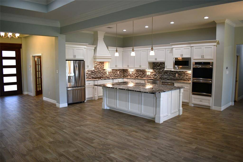 Featuring all porcelain tile flooring and custom tray ceilings throughout the home, complemented by crown molding. The home chef kitchen boasts an elegant South Asian marble island, perfect for culinary enthusiasts.
